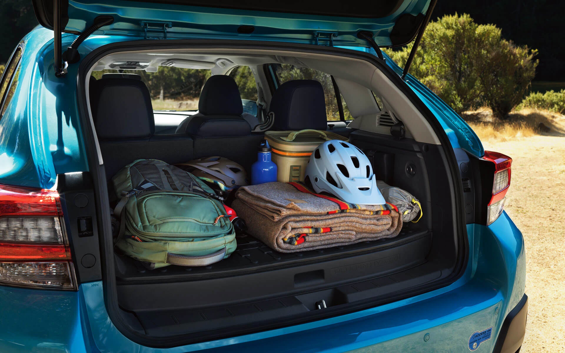 A backpack, blanket, and bike helmet in the rear cargo area of a Crosstrek Hybrid | Dean Team Subaru in Ballwin MO