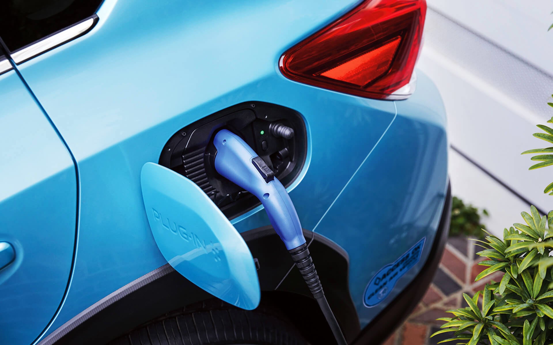 A close-up of the Subaru Crosstrek Hybrid's charging port with charging cable plugged in | Dean Team Subaru in Ballwin MO