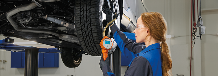 A Subaru technician checking tire pressure. | Dean Team Subaru in Ballwin MO