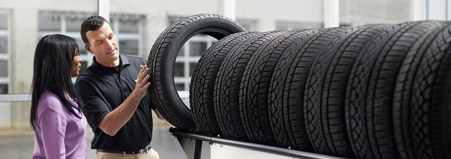 Subaru service representative showing customer a tire. | Dean Team Subaru in Ballwin MO