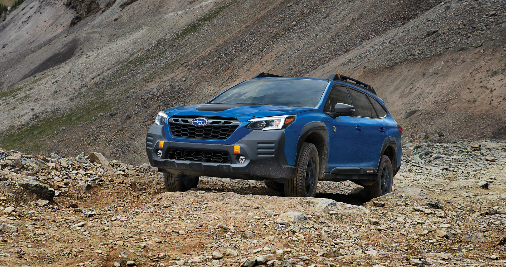 A 2023 Outback Wilderness driving on a trail in the mountains. | Dean Team Subaru in Ballwin MO