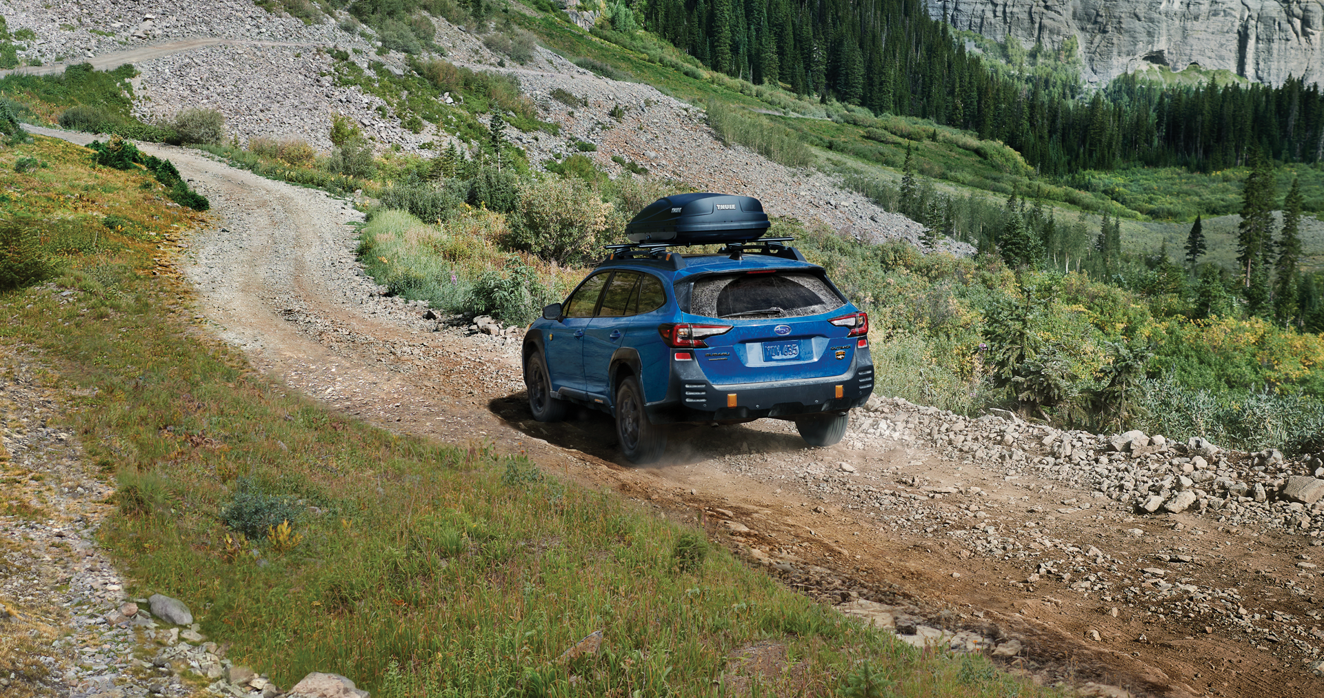 A 2023 Outback Wilderness driving on a trail in the mountains. | Dean Team Subaru in Ballwin MO